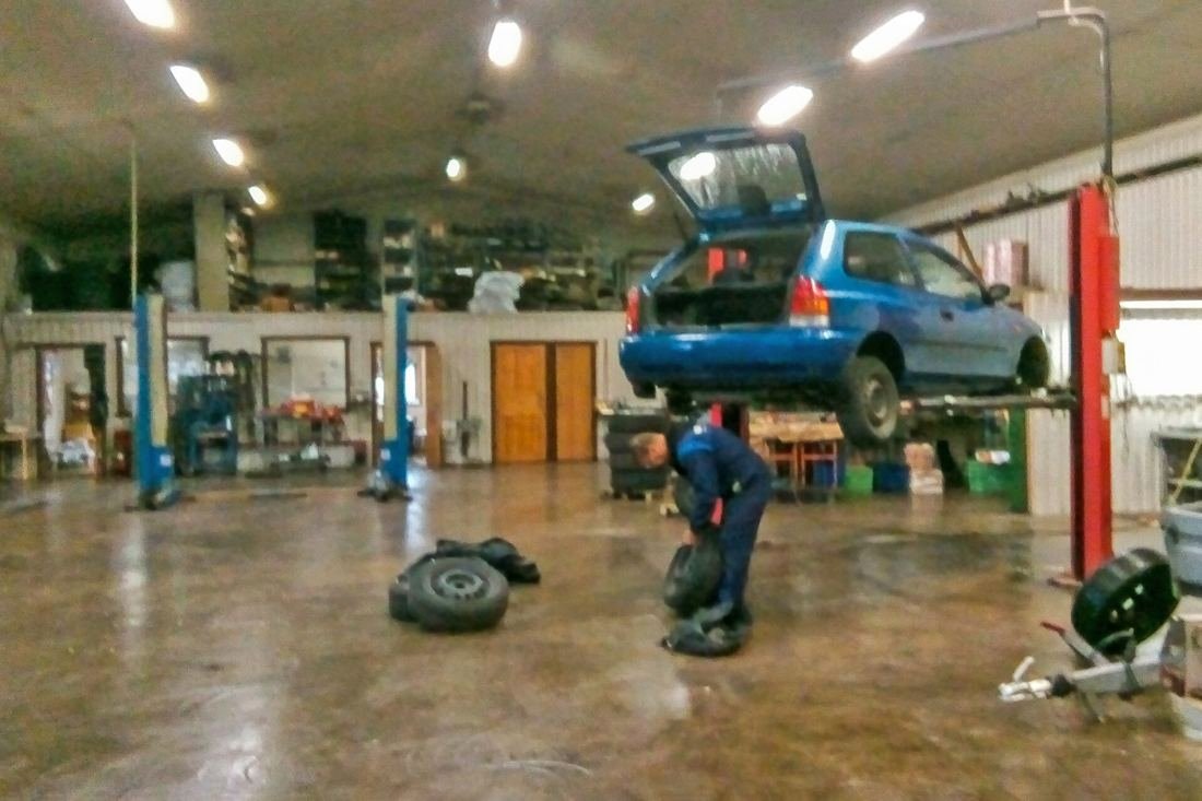Mechanik w rękawiczkach pracujący przy silniku samochodu